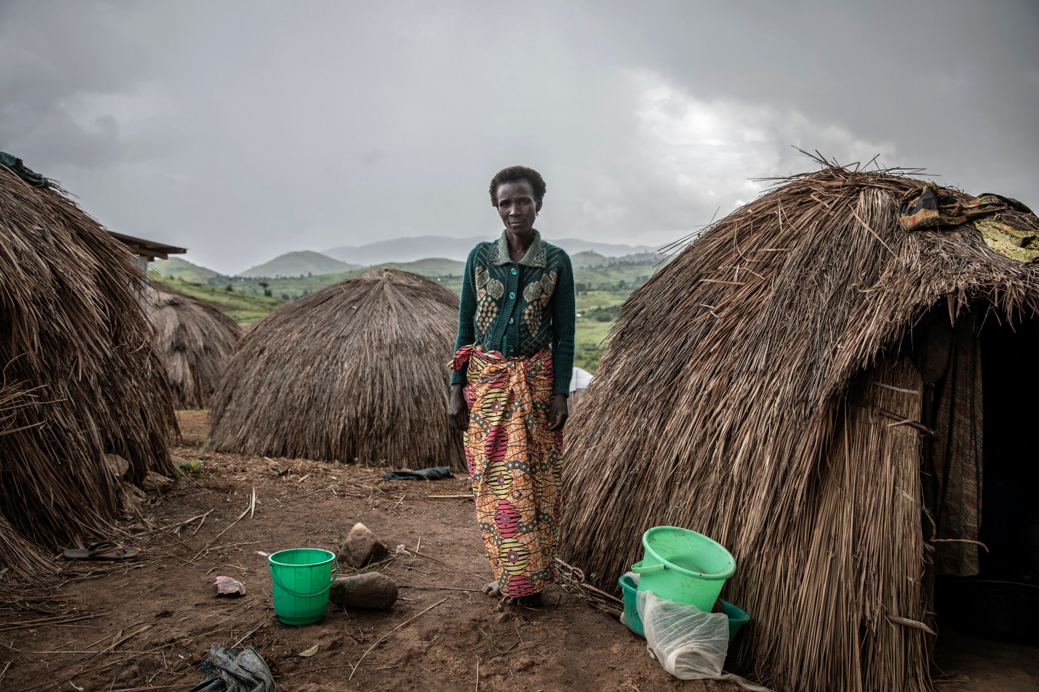 Kambe Site, Ituri Province, May 2021. Jeanne Borive, 45, who has eight children and who was separated from her husband when she fled her village of Lithe two and a half years ago, stands in a camp for people from the Hema community displaced by attacks by Lendu militias in Djugu territory. She spent four hours collecting wood to cook and to sell at the local market. "If there's peace I'll go back home. If not, I'll stay here," she said.
