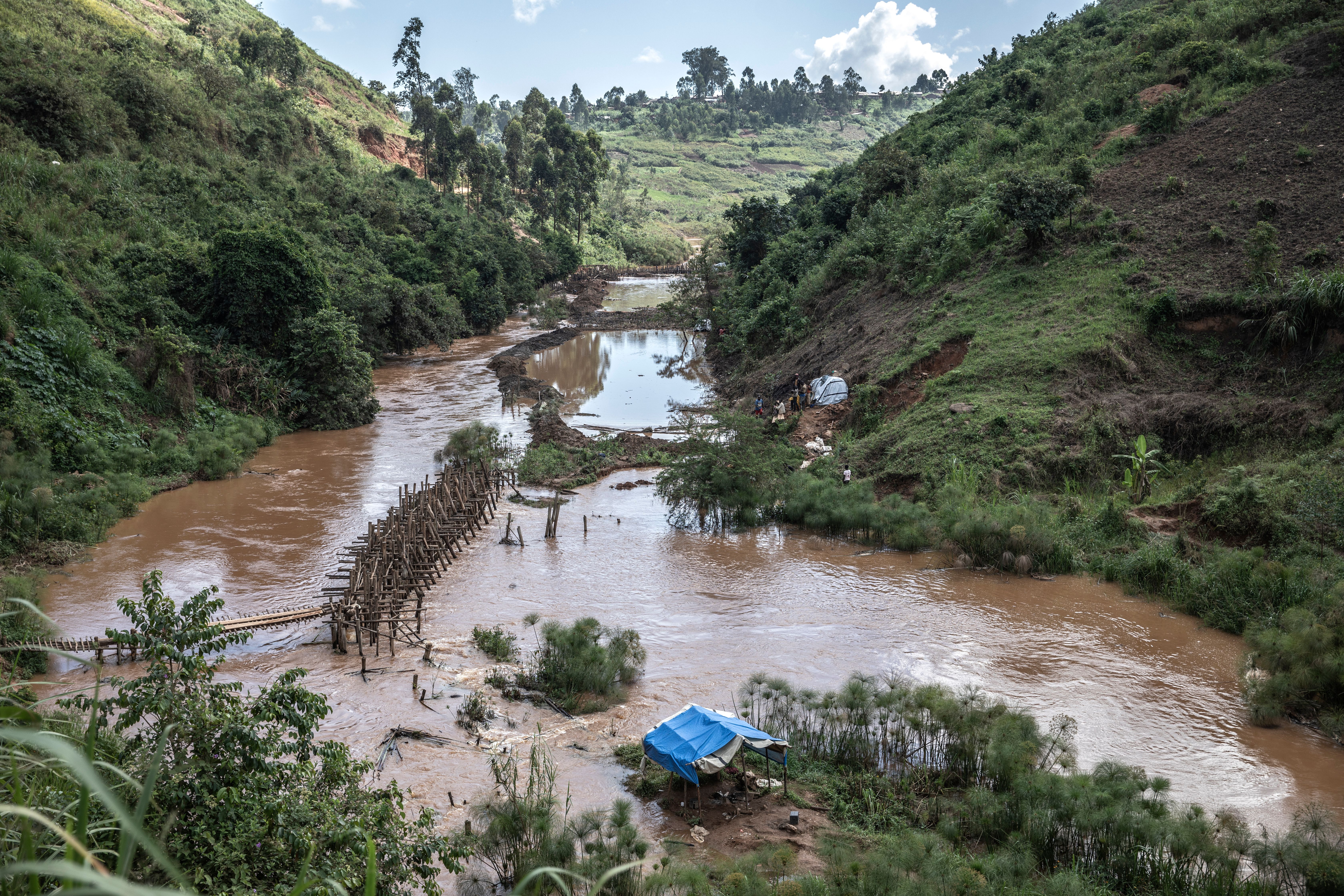 Iga Barrière, Ituri Province, May 2021. A diverted riverbank gold mine after heavy rain led to the mine being flooded overnight in Iga Barrière in Congo's Ituri province. Congo’s miners face plenty of risks excavating gold – 50 mostly young people died in a mine collapse last September – while health care and education for children is virtually non-existent. The coronavirus pandemic pushed up the global gold price to its highest value ever last August ($2,048 an ounce). Meanwhile, local prices offered from buyers in Africa went down, reflecting the imbalance in an international supply chain that exploits poor workers at the source of wealth. Hundreds of thousands of Congolese, including women and children, work in the informal mining sector, mostly in gold. Artisanal subsistence mining is the informal, small-scale mining done independently by people not officially employed by a mining company, using their own resources, usually by hand.