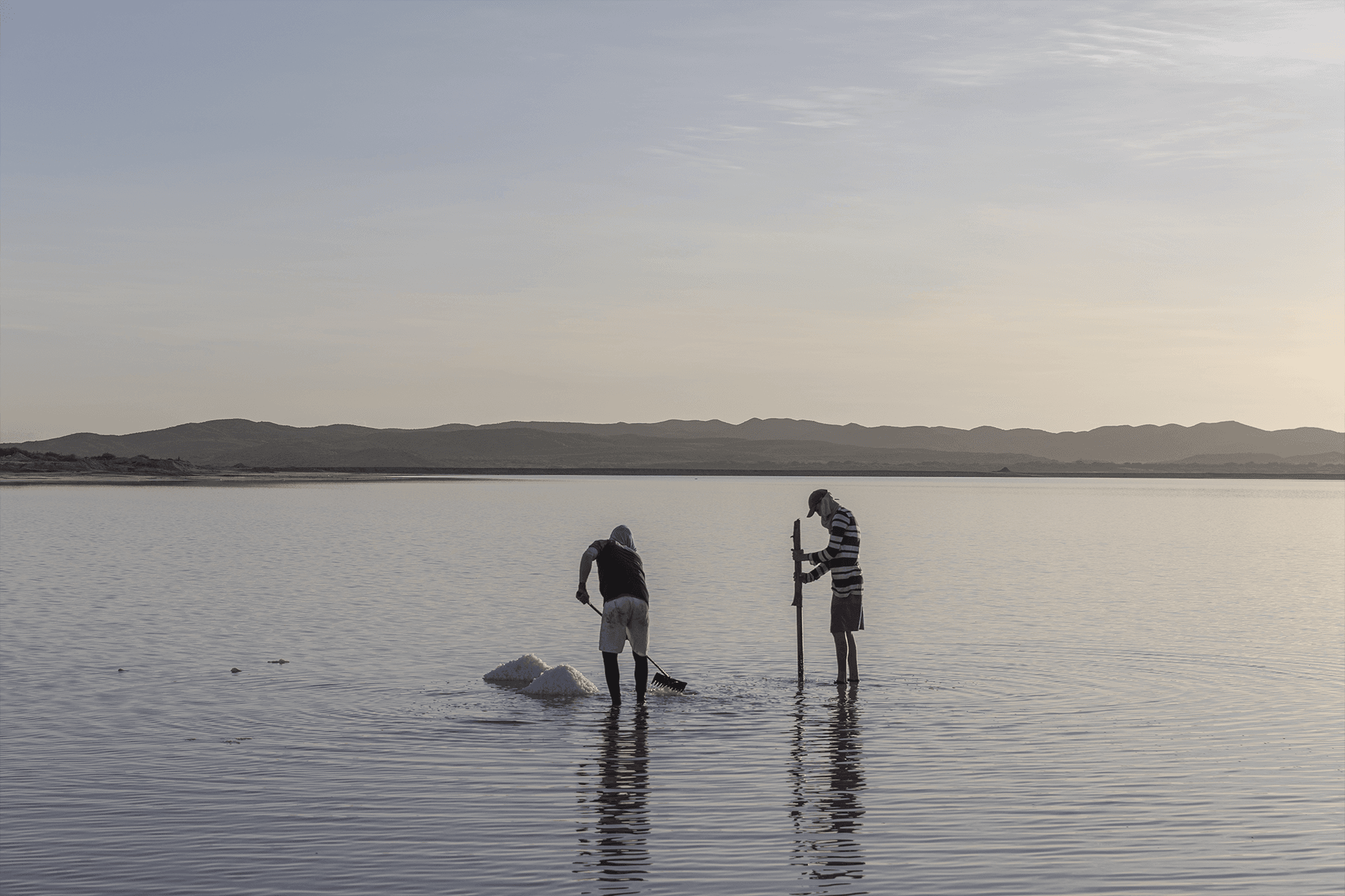 Araya, Sucre, 13th November 2021. Two men work on the Laguna Madre (Mother Lagoon), extracting salt in Araya - Fabiola Ferrero for Fondation Carmignac