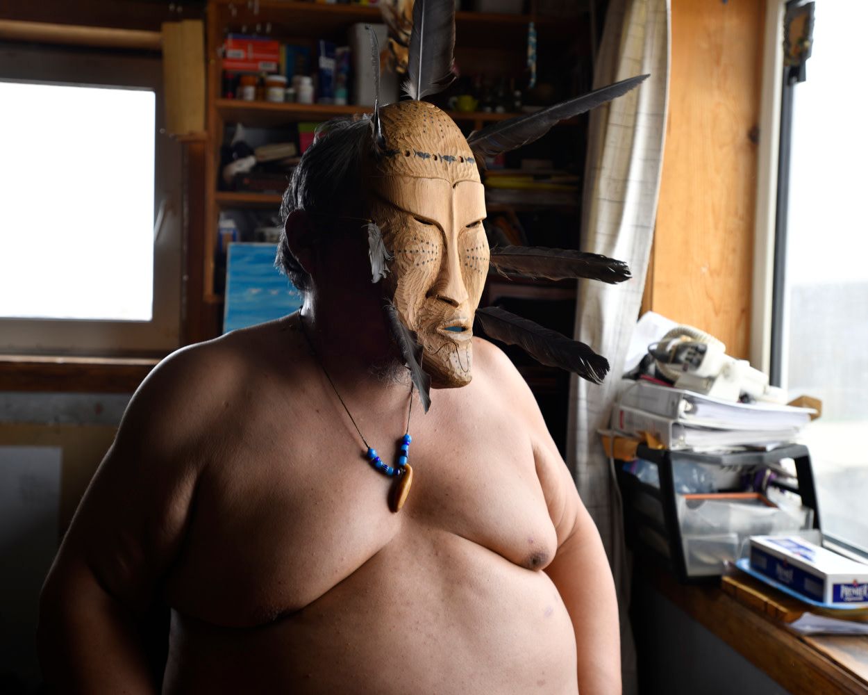 Point Hope, Alaska, USA, May 2018. Steve Ommituk, wearing a traditional iñupiat mask carved in driftwood, is a respected whale hunter whose livelihood is threatened by the early disappearance of sea ice.